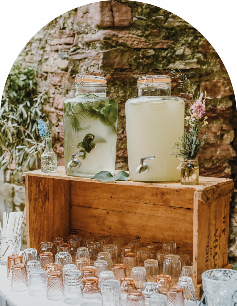 Présentation de nos fontaines à boissons pour un service autonome. Eau aromatisée au concombre et à la menthe fraîche, ainsi que citronnade maison au gingembre. Verrerie vintage pour une ambiance de mariage rétro.